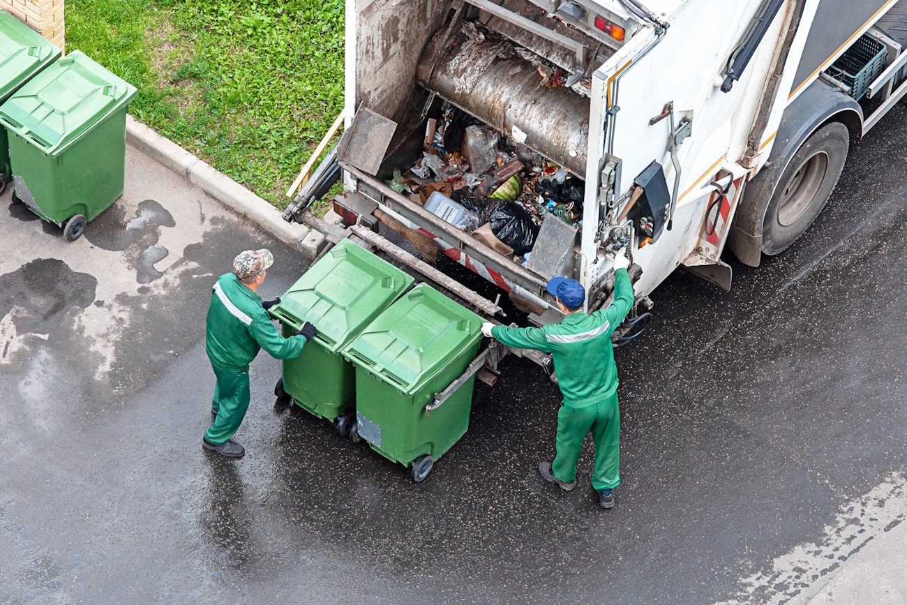 two workers loading mixed domestic waste in waste collection